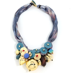 Detail of luxury silk ribbon necklace with metal flower pendant and blue buttons