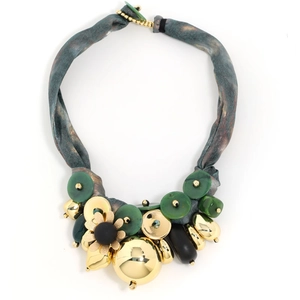 Detailed close-up of a luxury statement necklace with green resin and gold flower pendant