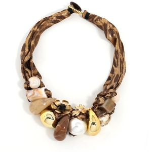 Statement necklace with leopard print fabric, gold flowers, and pearls on white background