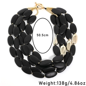 Detailed view of multilayer beaded necklace with matte black beads and golden toggle clasp