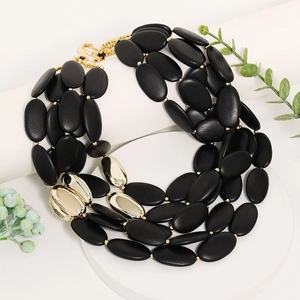 Multilayer black and gold beaded statement necklace in bohemian style on display