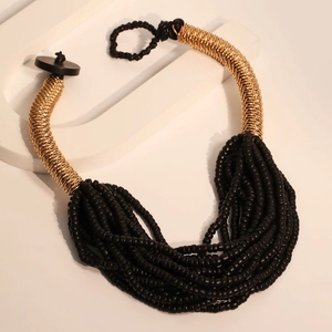 Elegant multi-layer black beaded necklace with vintage gold wire trim on stone display