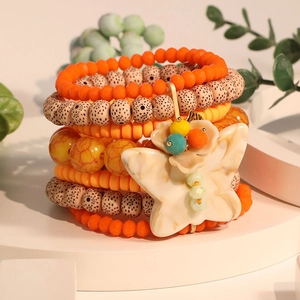 Bohemian multilayer beaded stretch bracelet featuring a resin butterfly pendant and floral accents