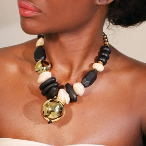 Retro beaded necklace with black geometric beads, cream pearls, and gold sphere pendant