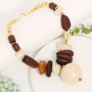 Detailed view of bohemian necklace with wood beads, amber resin, and large cream pearl pendant