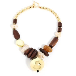 Macro view of ethnic beaded necklace featuring gold metal beads and a large polished sphere