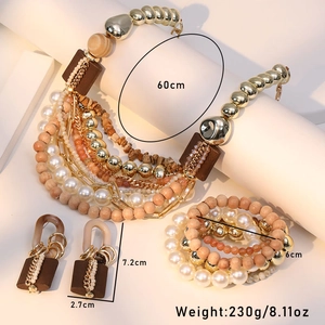 Detailed view of layered necklace set with pearls, wood beads and metal chains