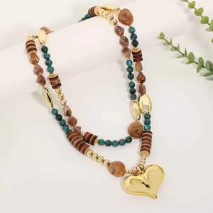 Mehrlagige Boho-Perlenkette mit großem goldenem Herzanhänger auf modernem Display