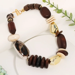 Handmade wooden beaded necklace with leopard print bead and gold accents on white stand
