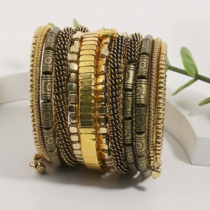 Detail view of multi-layer beaded bracelets in antique gold with solar pattern charms