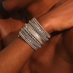Detail of stacked bohemian silver multilayer beaded and snake chain bracelets on wrist