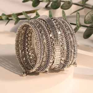 Macro view of multi-layer beaded silver wrap bracelet on a geometric white pedestal
