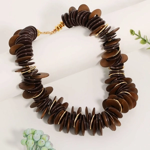 Multilayer necklace with brown wooden disks and golden metal rings in vintage bohemian style