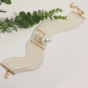 Elegant multi-layer pearl necklace with gold metal bars and a large center pearl