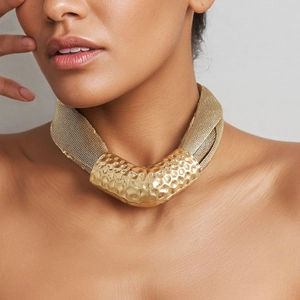 Statement gold mesh chain necklace featuring a hammered metal V-shaped tube pendant
