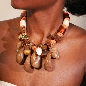 Detail of bohemian braided rope necklace with teardrop beads on a model neckline