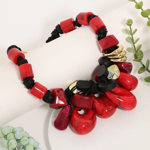 Detailed close-up of bohemian multi-layer necklace with red resin beads and gold accents