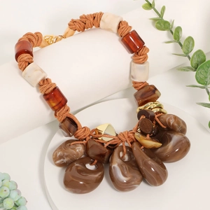 Detail of bohemian braided rope necklace with marble texture resin pendant and wood discs