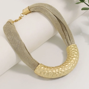 Statement necklace featuring golden mesh chain and hammered U-shape metal tube detail