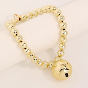 Minimalist golden bead necklace with large sphere pendant and toggle clasp on display
