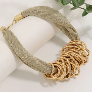 Golden mesh chain necklace with interlocking rings shown on a white display stand