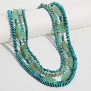 Close-up of a multi-layer beaded necklace with teal stones and translucent oval charms