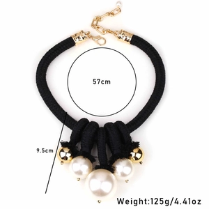 Macro detail of cream knotted necklace with faux pearls and polished gold beads