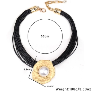Détail du pendentif doré martelé avec perle blanche et collier de 53cm à cordons cirés