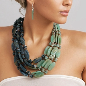 Multilayered green beaded acrylic necklace with large gradient resin stones on model