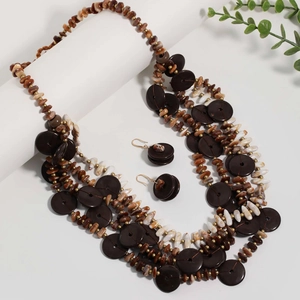 Detail of five-layer beaded necklace with dark brown wooden discs and boho shell pieces