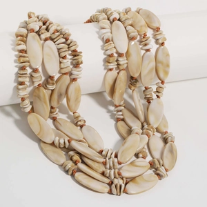Close-up of multilayer beaded necklace with beige marble beads and brown braided cord
