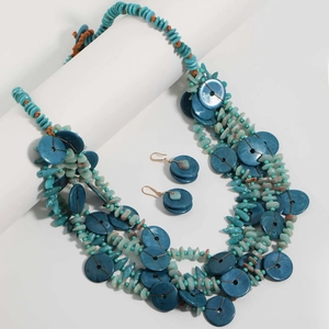 Close-up of bohemian layered beaded necklace and earrings set with turquoise stones
