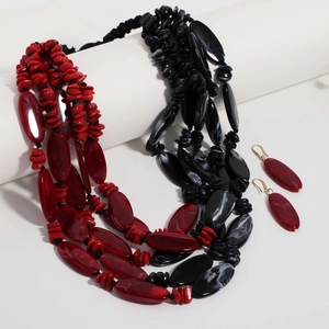 Detail of red and black acrylic multi-layer beaded necklace and matching earrings