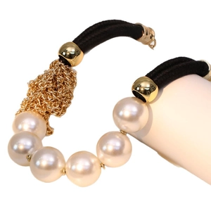 Elegant beaded pearl choker with gold chain details on a white display stand