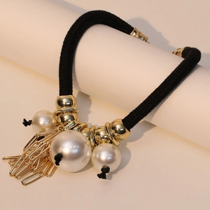 Bohemian woven cord necklace with large pearls and gold paperclip fringe on a white spool