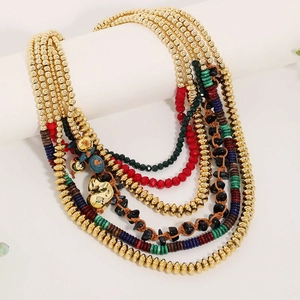 Dettaglio collana boho multistrato con perline colorate e ciondolo a cuore dorato