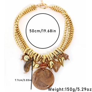 Detailed view of layered golden beaded necklace with brown marble resin round pendant