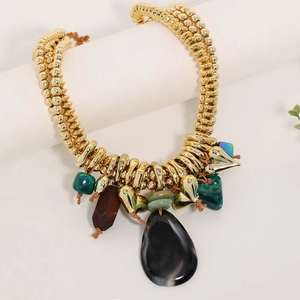 Close-up of golden CCB beads with black textured drop and malachite style pendants