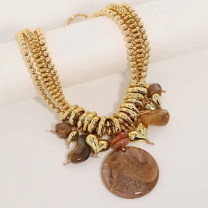Close-up of bohemian layered beaded necklace with marble resin and golden heart charms