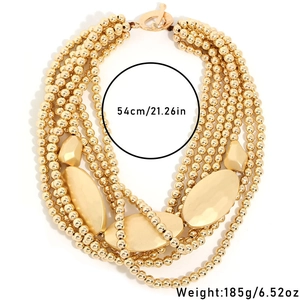 Multi-layer gold bead necklace with geometric charms and toggle clasp on white background