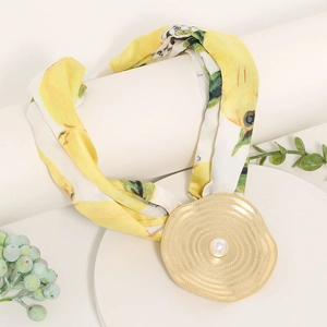 Floral print fabric necklace with a large golden spiral pendant and central pearl