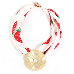 Silk-style strawberry print necklace with a large golden concentric ripple disc pendant
