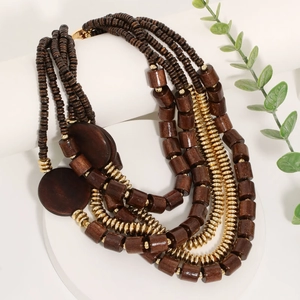 Five-layer vintage wooden and gold beaded necklace displayed on white geometric stands
