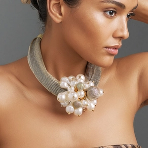 Collier ras de cou doré tissé avec bouquet de fleurs en perles porté par un modèle