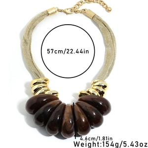 Macro view of teardrop marble resin pendants on a gold braided mesh chain necklace
