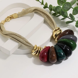 Detail of creative teardrop pendants on a gold woven mesh chain for women