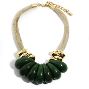Close-up of gold mesh chain and dark green teardrop pendants on a statement necklace