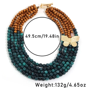 Close-up of multi-layer beaded necklace with wooden beads and golden butterfly pendant