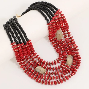 Multilayer acrylic beaded necklace with red stones and gold accents on a white stand