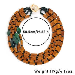 Detail of bohemian layered necklace showing brown wood beads and green resin stones